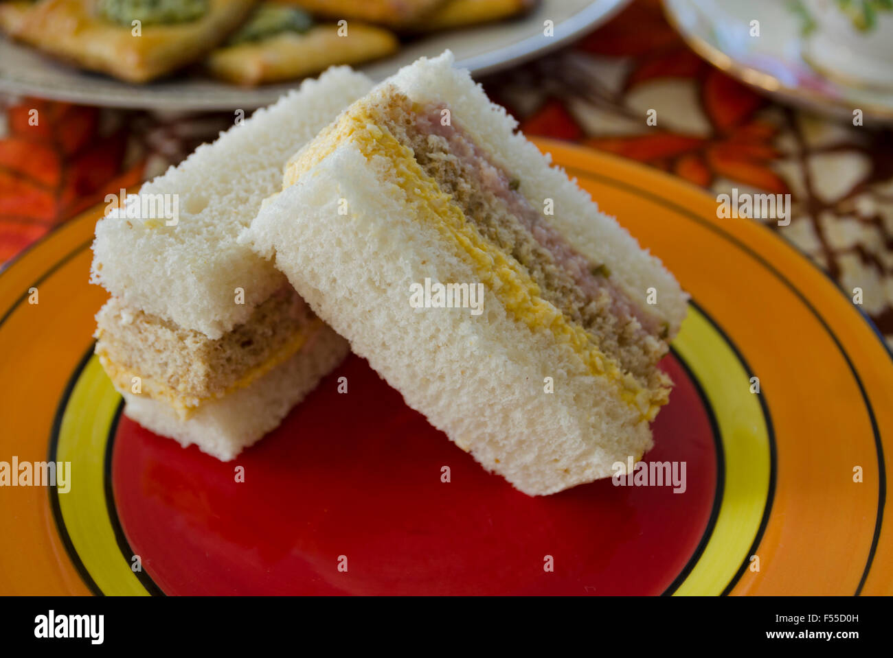 Drei Layer crustless Sandwiches mit Ei, Salat und gehacktem Schinken. Auf eine Platte für den Nachmittagstee. Stockfoto