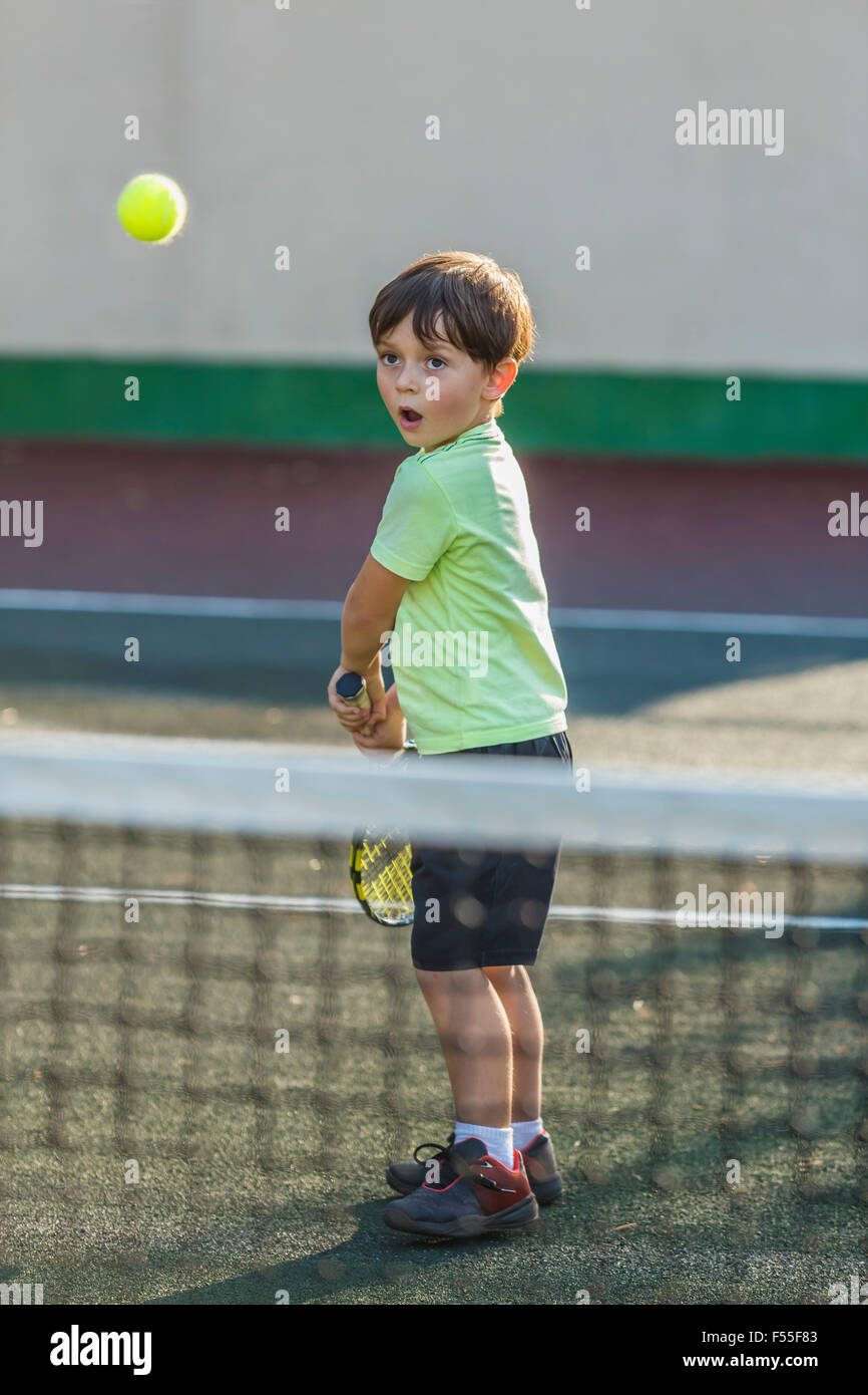 Junge, spielen Tennis auf Feld am Hof Stockfoto
