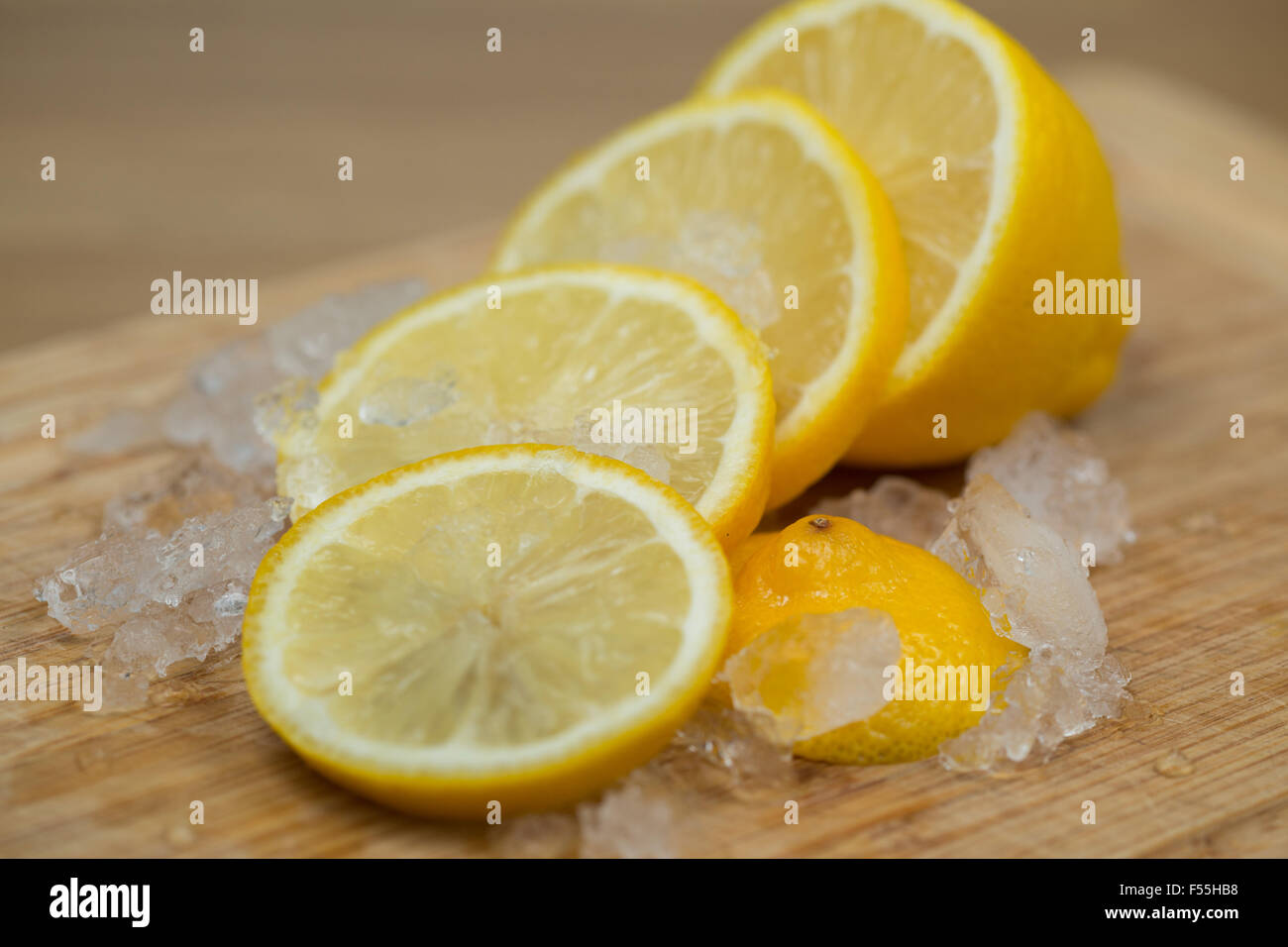 Eine frische Zitrone in Scheiben geschnitten auf ein Schneidbrett aus Holz. Stockfoto