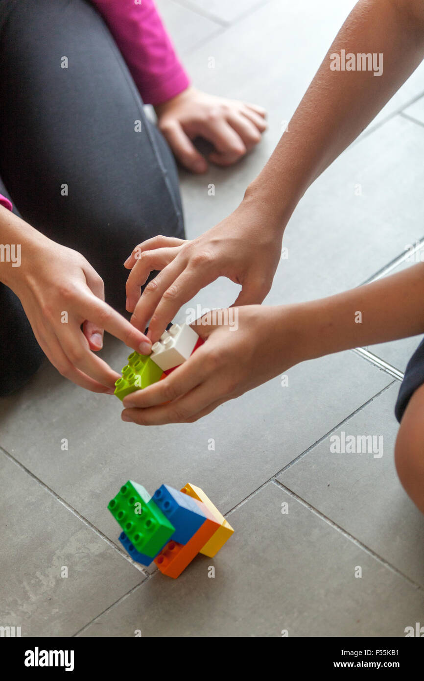Kunststoff Würfel in der Hand des Kindes Spiel, entwickelt Kreativität und Phantasie, Legosteine Kinder Hände spielen mit bunten lego Bausteine Stockfoto