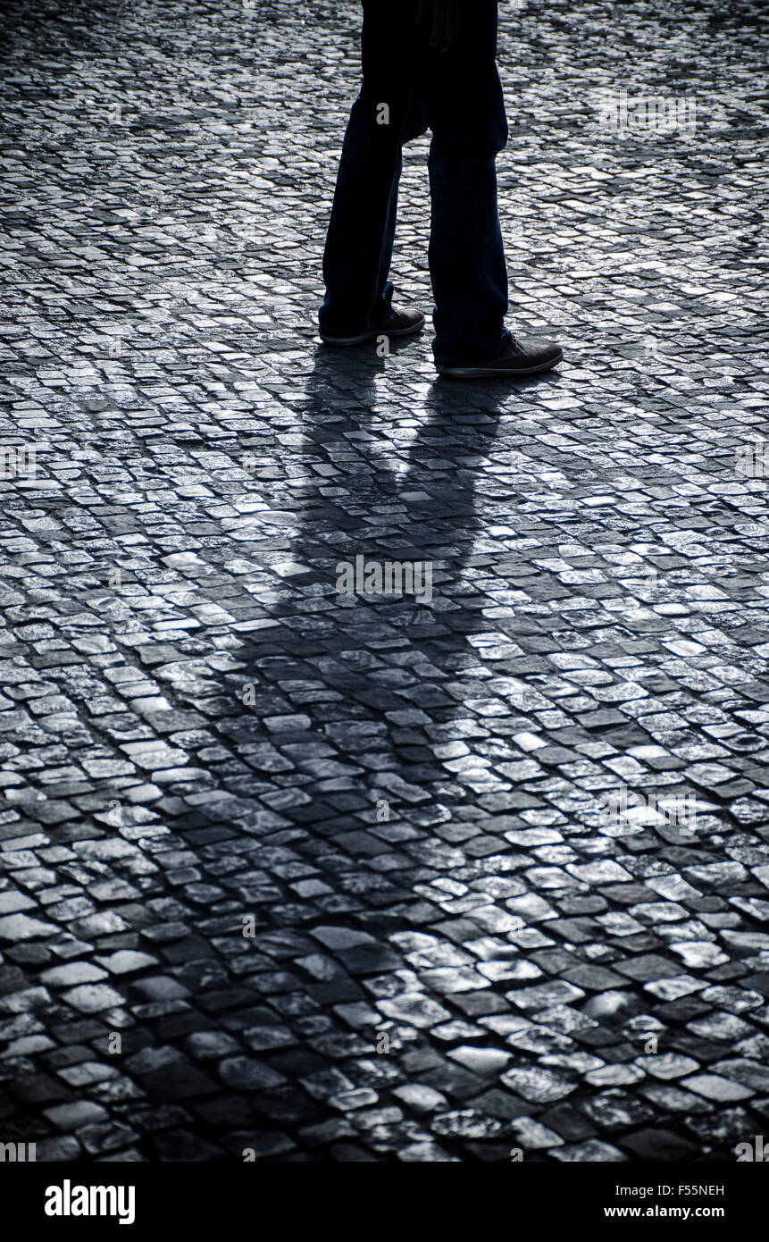 Geheimnisvolle Mann zu Fuß auf einer gepflasterten Straße Stockfoto