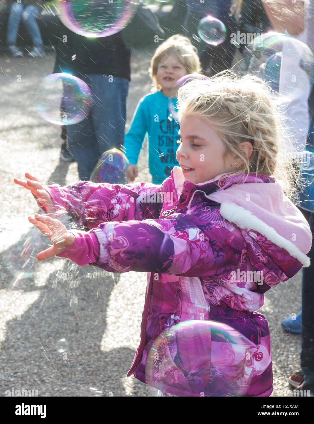 junges Mädchen spielen, spielen mit Luftblasen Stockfoto