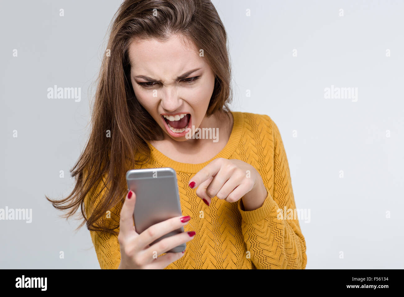 Porträt von wütenden Frau schreiend auf dem Handy isoliert auf weißem Hintergrund Stockfoto