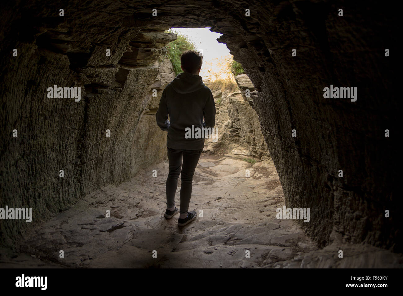 Junge Mann in dem Tunnel in Tintagel Castle Stockfoto