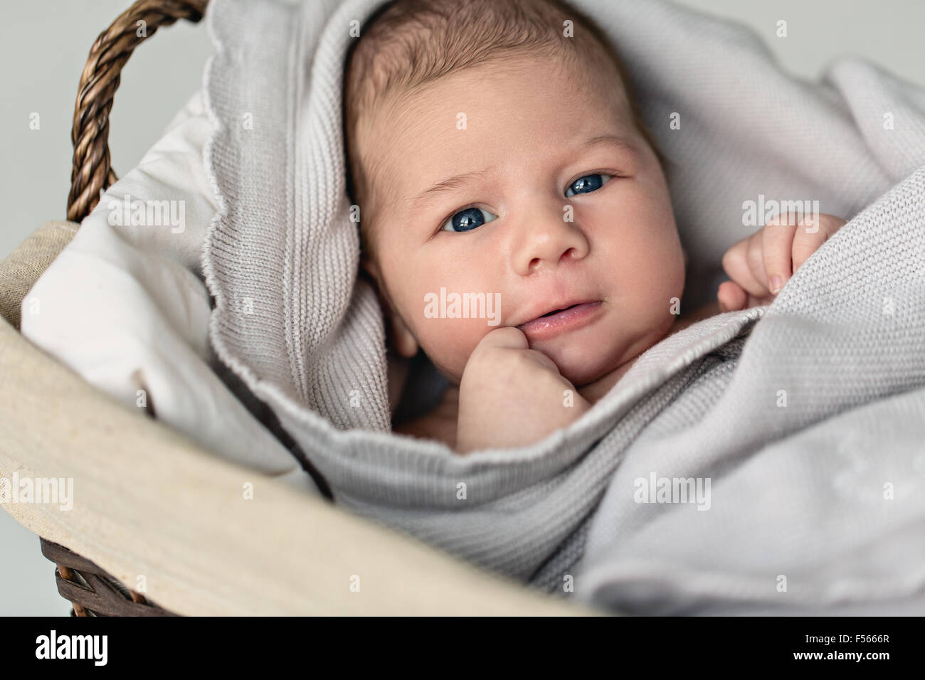 Neugeborenes Baby Boy liegen im Inneren der Weidenkorb Stockfoto
