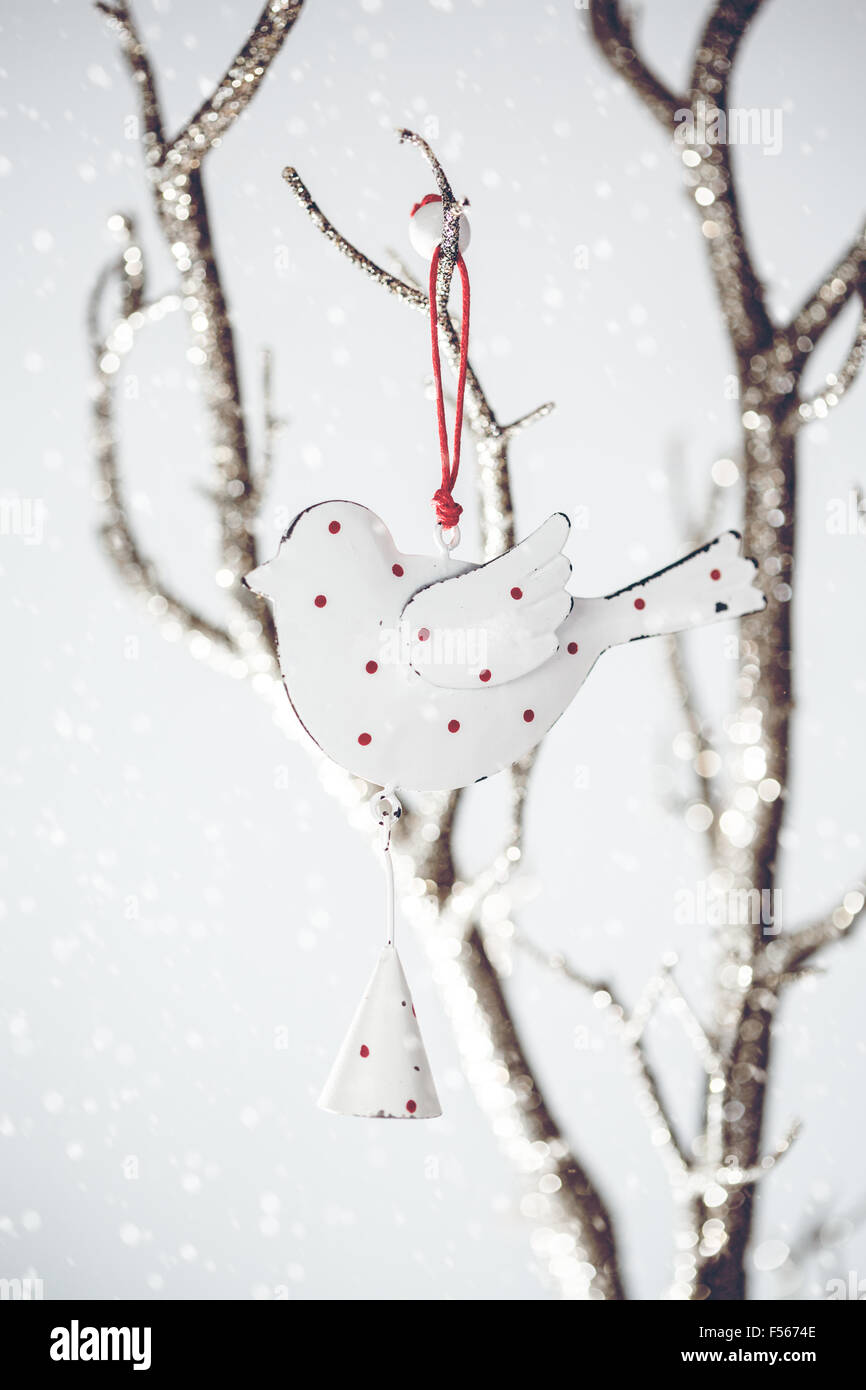 Weihnachts-Dekoration. Vintage Spielzeug Vogel auf einem silbernen Ast mit gezeichneten Schnee für festliche Stimmung. Retro-Konzept. Selektiven Fokus. Stockfoto