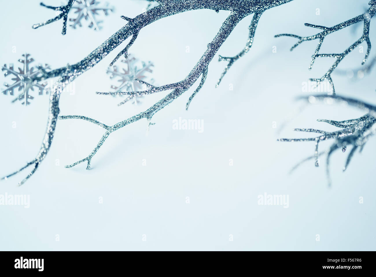 Weihnachten-Grenze. Silberne Zweig und metallischen Schneeflocken auf hellem Hintergrund. Selektiven Fokus. Platz für Text. Bild getönt. Stockfoto