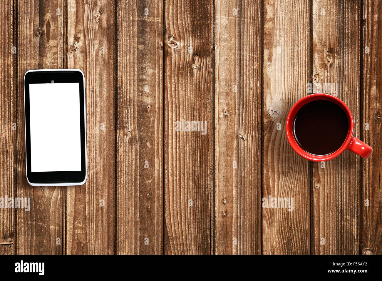 Handy und Kaffeetasse auf Holztisch Stockfoto
