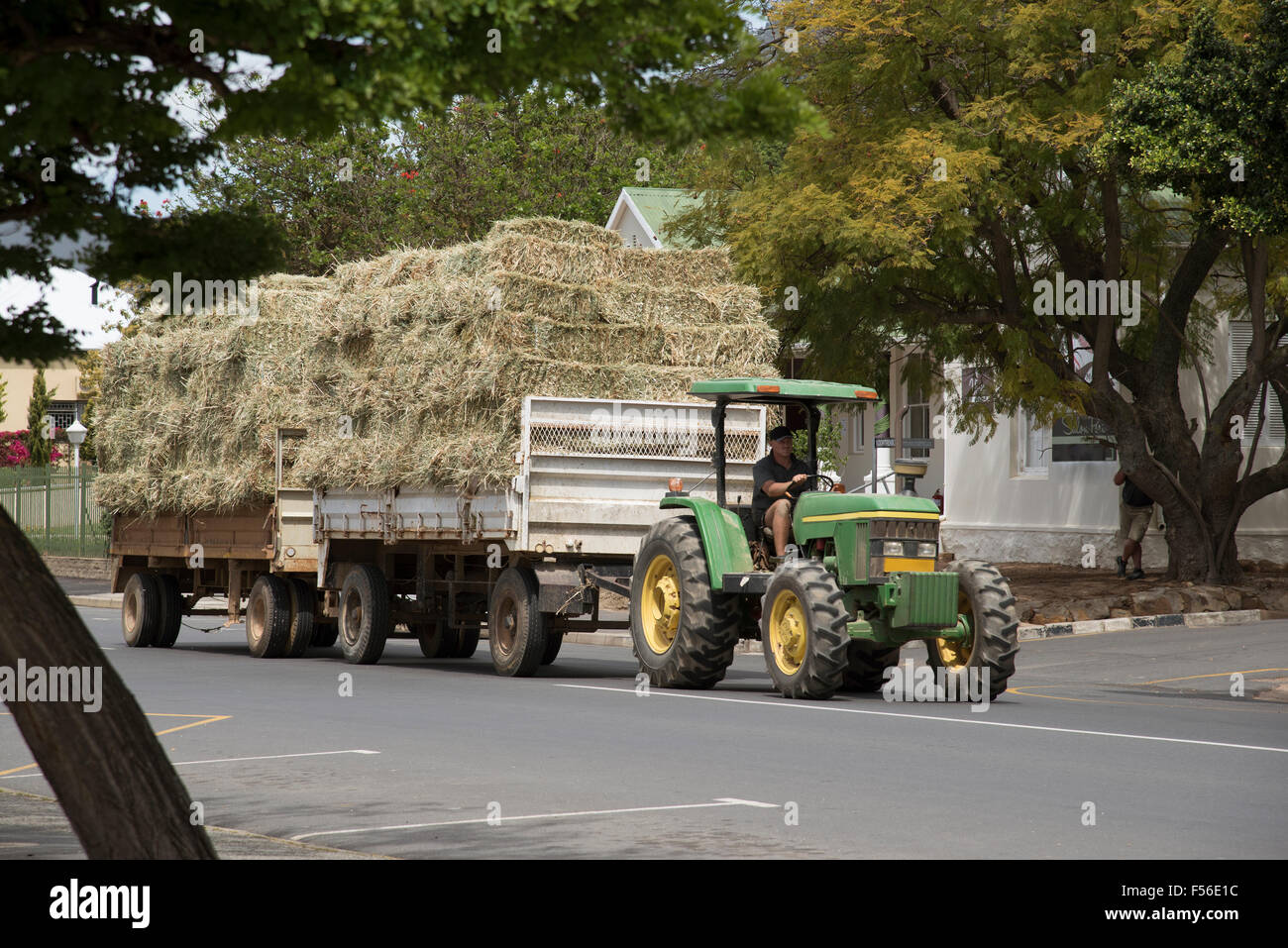 Bauernhof Traktor und Anhänger von Stroh vorbei durch die Stadt Riebeeck West in der Swartland Region Südafrika Stockfoto