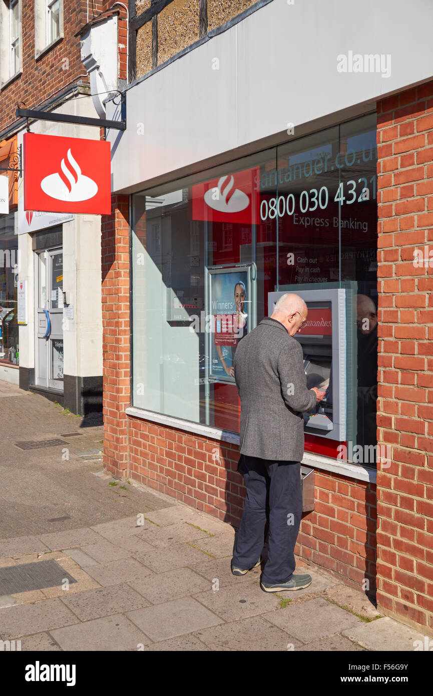 Ein Mann Bargeld von Geldautomaten der Santander in Hitchin, England, Vereinigtes Königreich UK Stockfoto