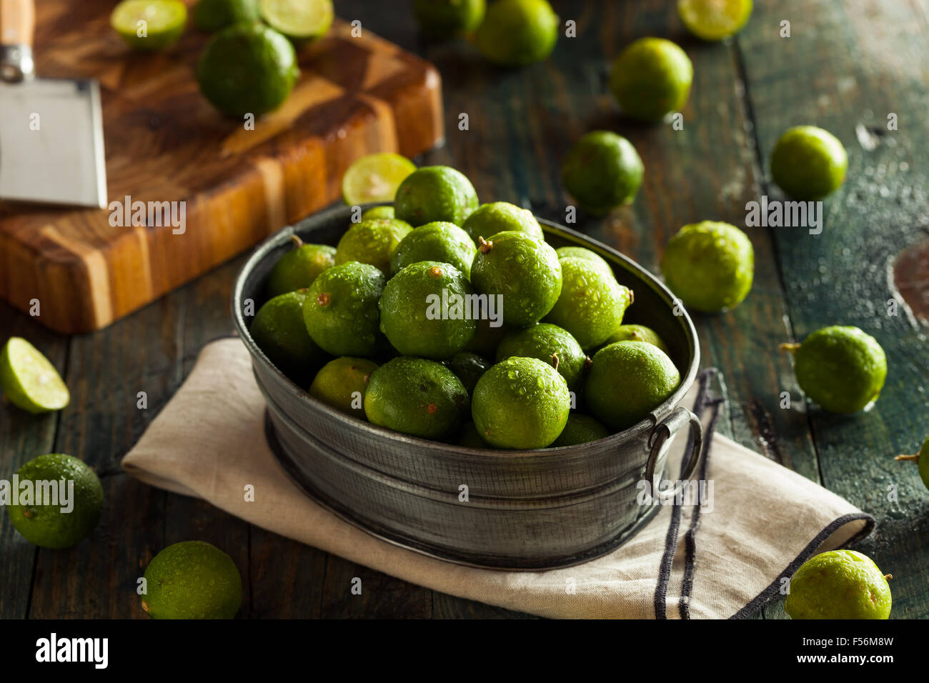 Rohe grüne Bio Key Limes in eine Schüssel geben Stockfoto