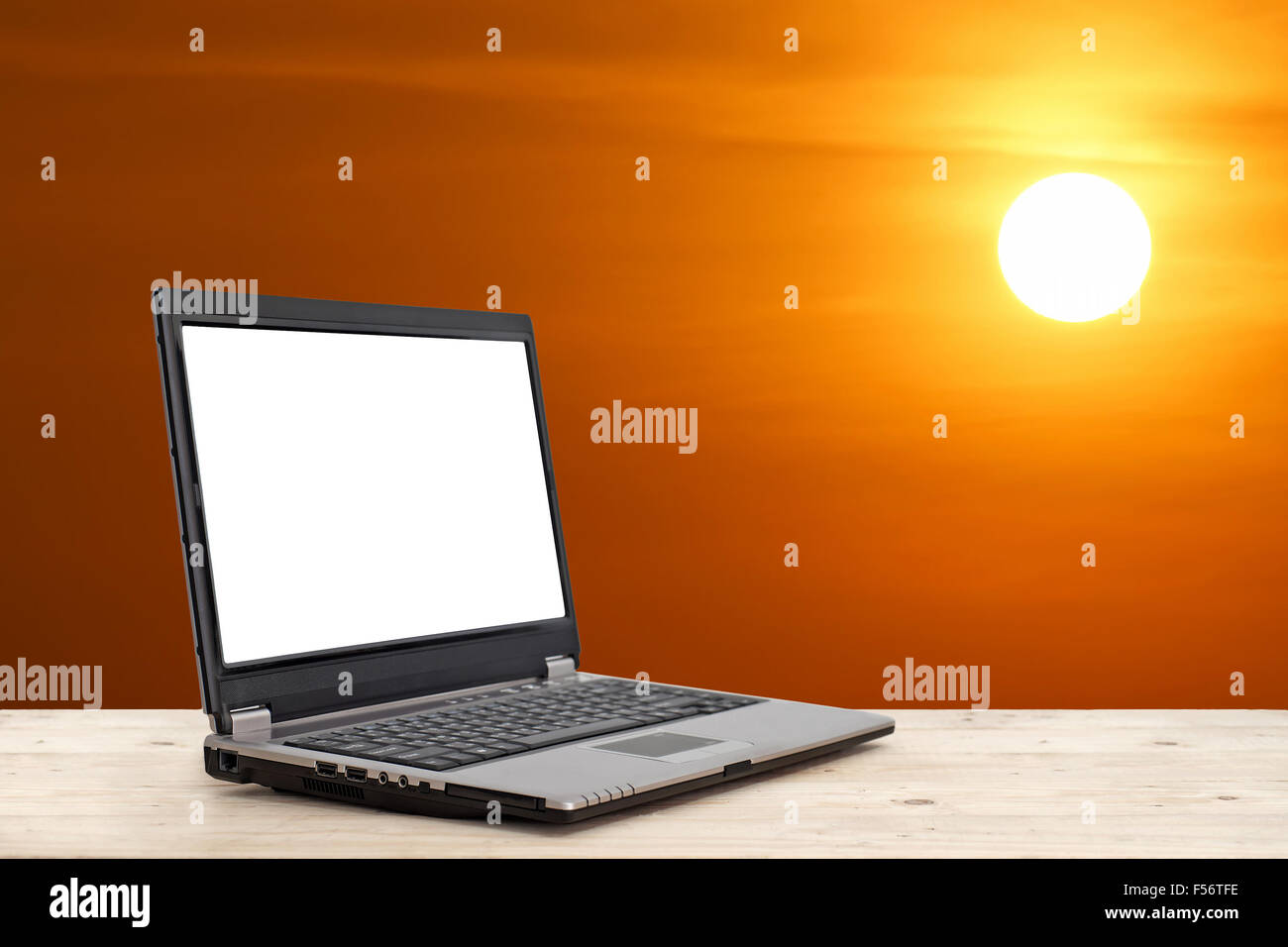 Business Konzept-Idee, Laptop mit leeren Bildschirm auf Holztisch mit schönen Sonnenuntergang Hintergrund Stockfoto