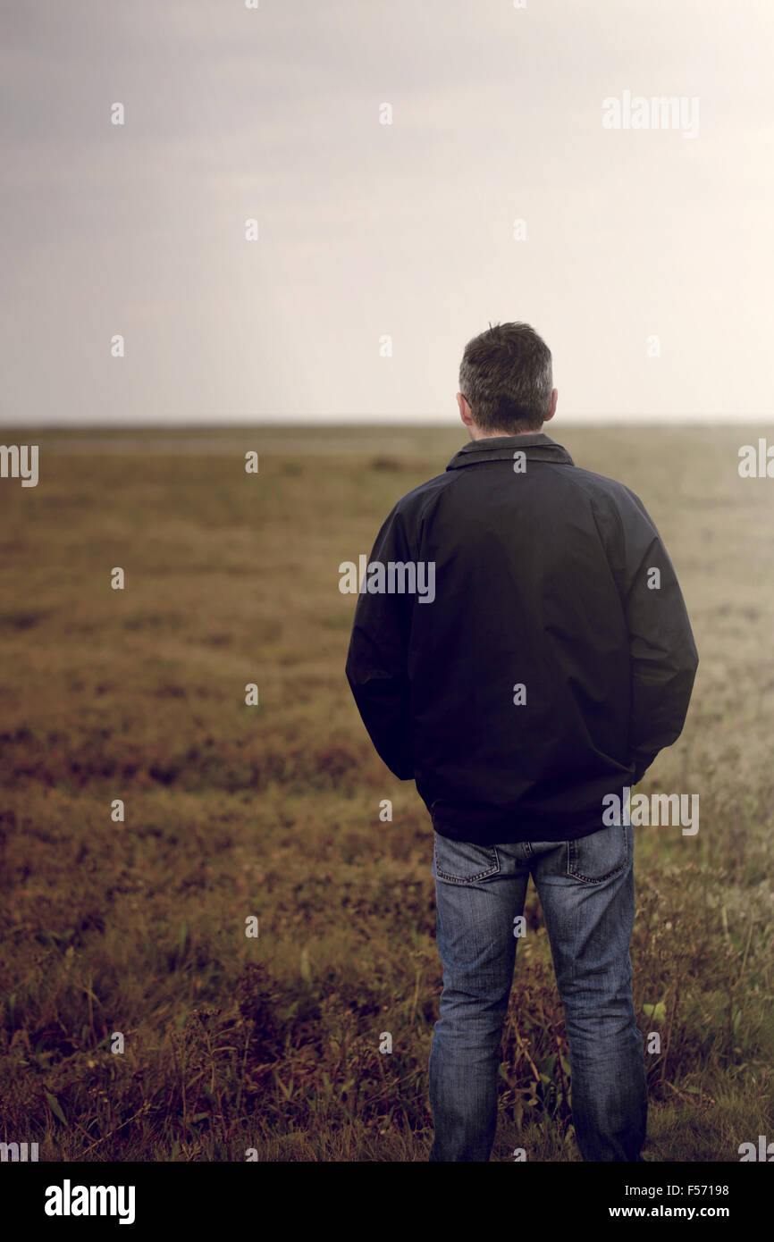 Hübscher Mann mittleren Alters zu Fuß durch eine ländliche Küstenregion Stockfoto