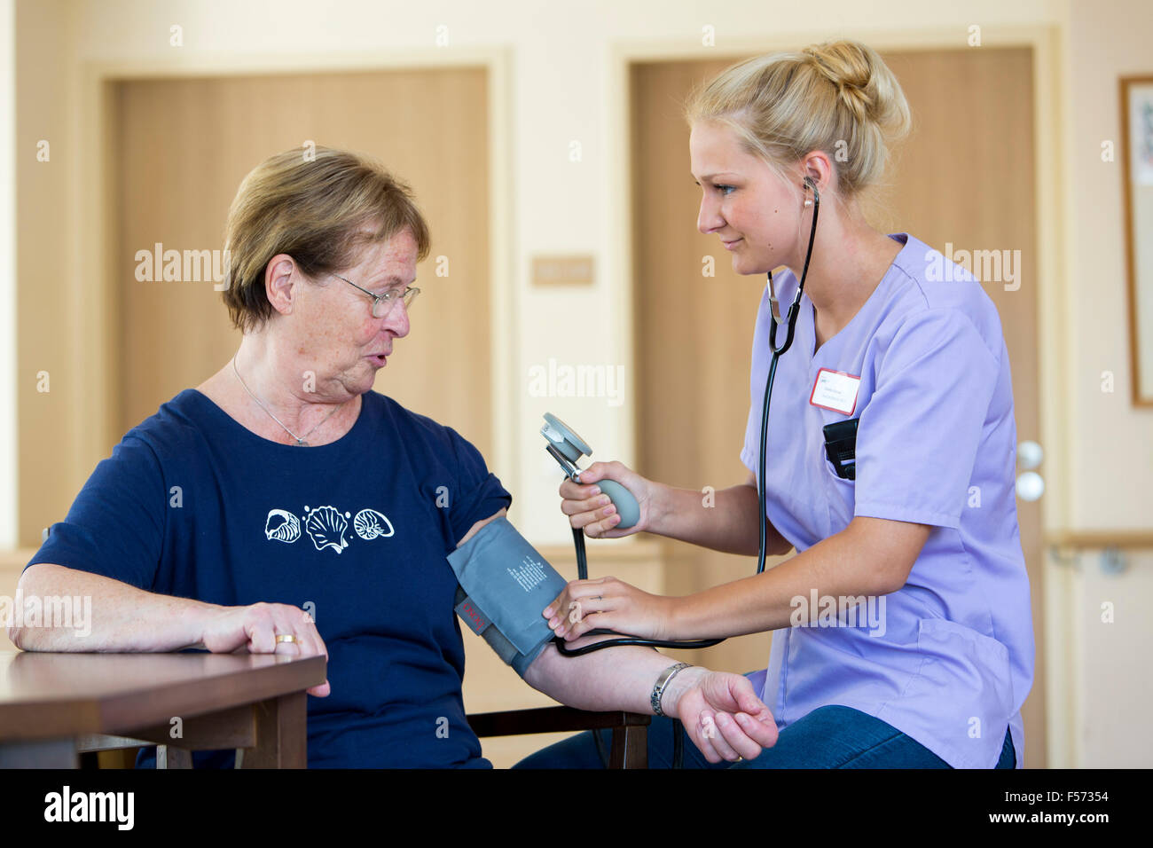 Altenpflege in einem Pflegeheim, Krankenschwester, Blutdruck messen, Stockfoto