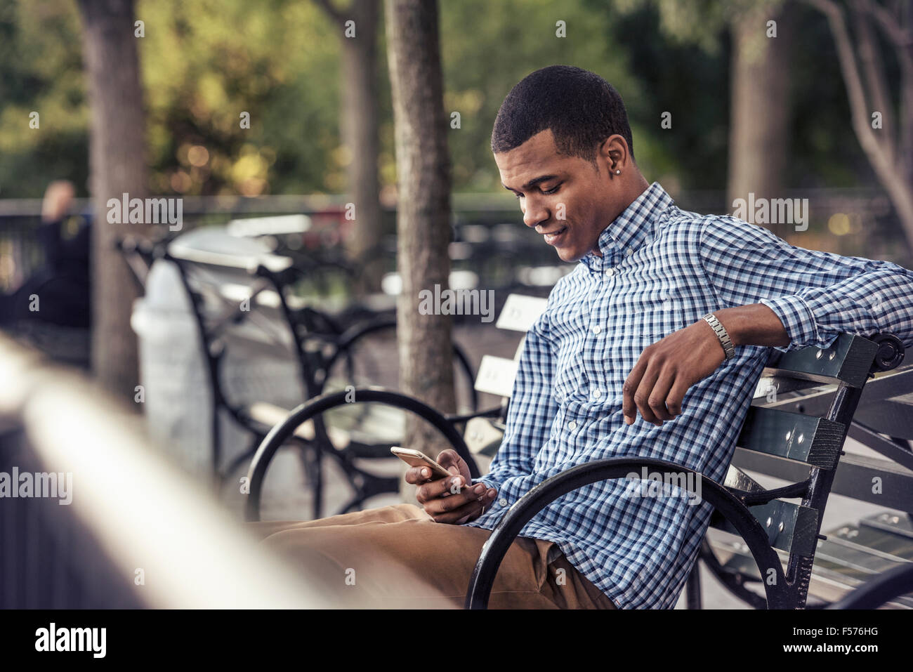 Ein Mann in einem Park, Blick auf ein smart phone Stockfoto