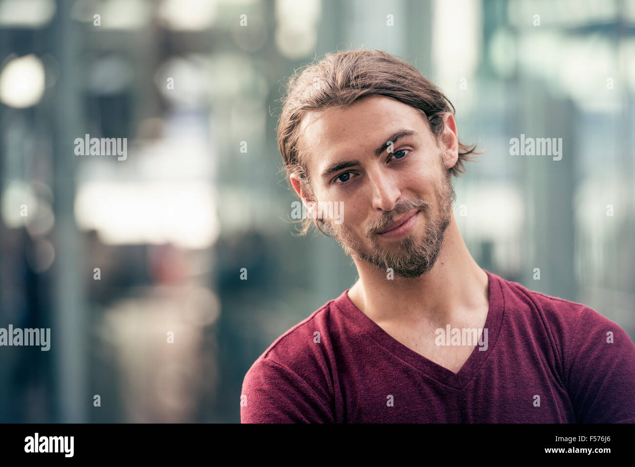 Porträt eines lächelnden jungen Mannes in einer Straße in der Stadt Stockfoto