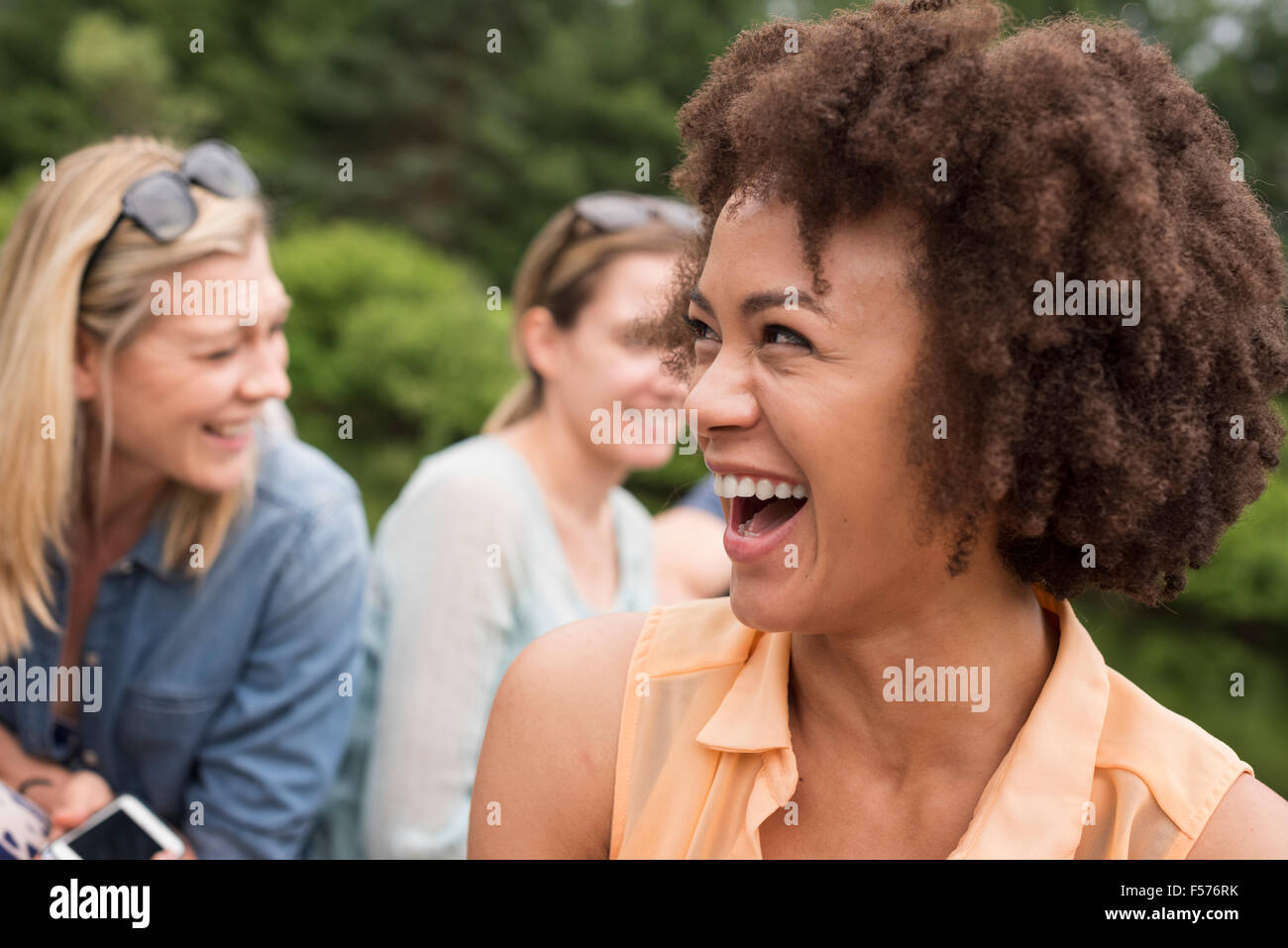 Eine Frau in einer Gruppe von Freunden im Freien zu lachen. Stockfoto