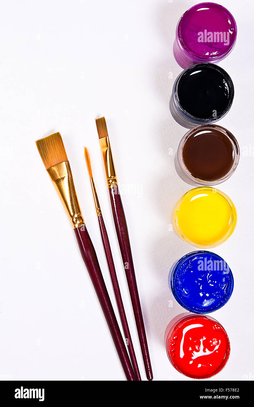 Flaschen mit Gouache Farben und verschiedene Arten von Bürsten für künstlerische Gemälde auf dem weißen Hintergrund. Stockfoto