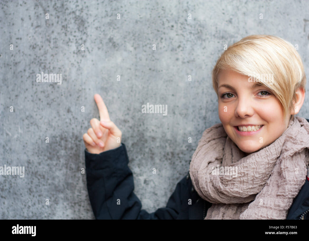 Attraktive junge Frau zeigte mit dem finger Stockfoto