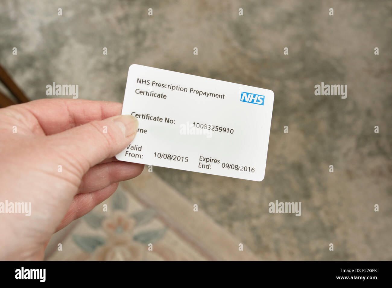 Frau hält eine NHS-Rezept-Vorauszahlung Zertifikat (nützlich, wenn viele Medikamente stammt z. B. 2 oder mehrere Skripts pro Monat) Stockfoto
