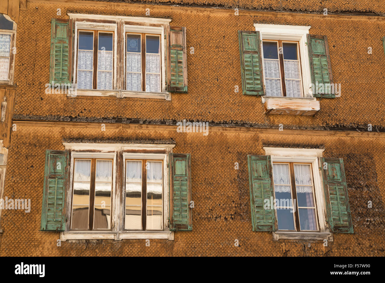 Schweizer Alpine House Nahaufnahme von Holzschindeln und Fenster in Wänden mit grünen Fensterläden. Stockfoto