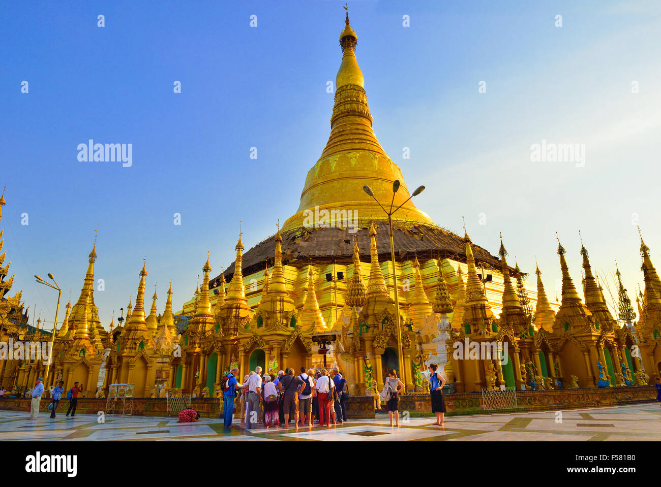 Touristen versammeln sich um Führer auf späten Nachmittag Tour in Shwedagon Pagode, Yangon die heiligste buddhistische Pagode in Myanmar, Burma Stockfoto