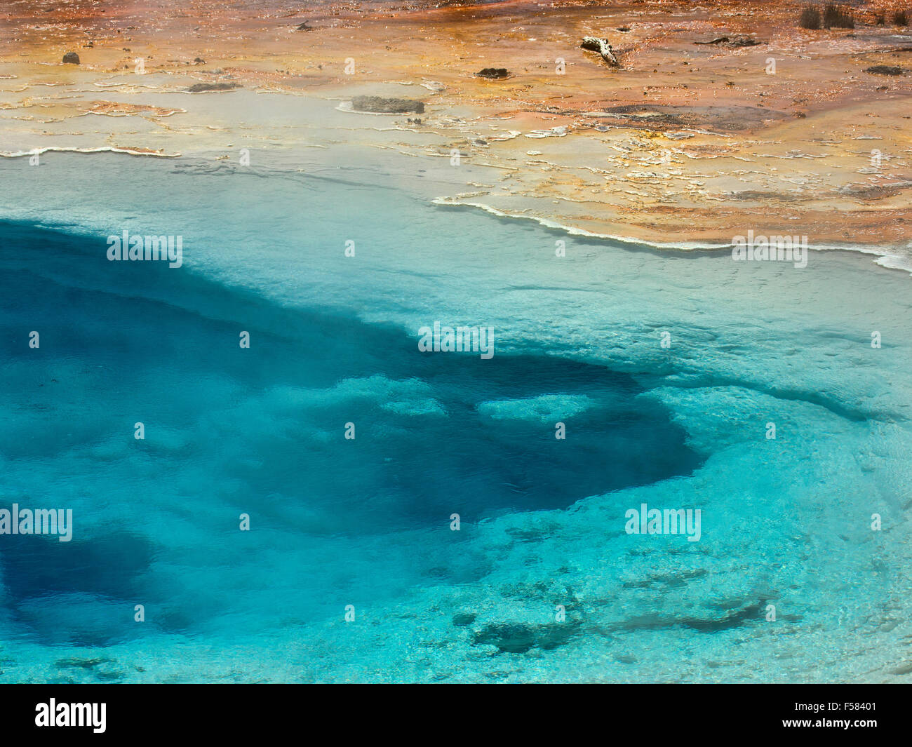 Blaue Feder Geysir, Yellowstone-Nationalpark. Lebendige kristallklare kontrastreiche Rost farbige mineralische Ablagerungen. Stockfoto