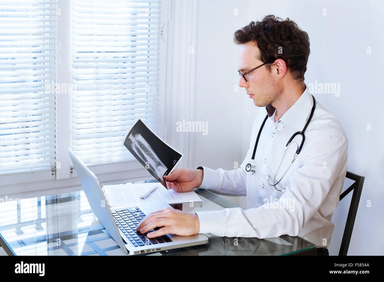 Arzt vor Computer Überprüfung Xray Foto Stockfoto