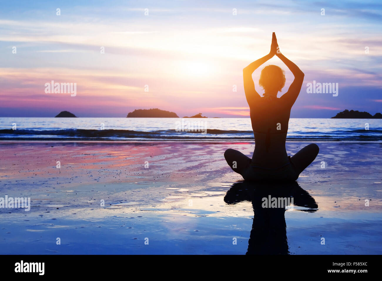 Yoga Hintergrund, abstrakte Silhouette Frau meditieren am Strand Stockfoto