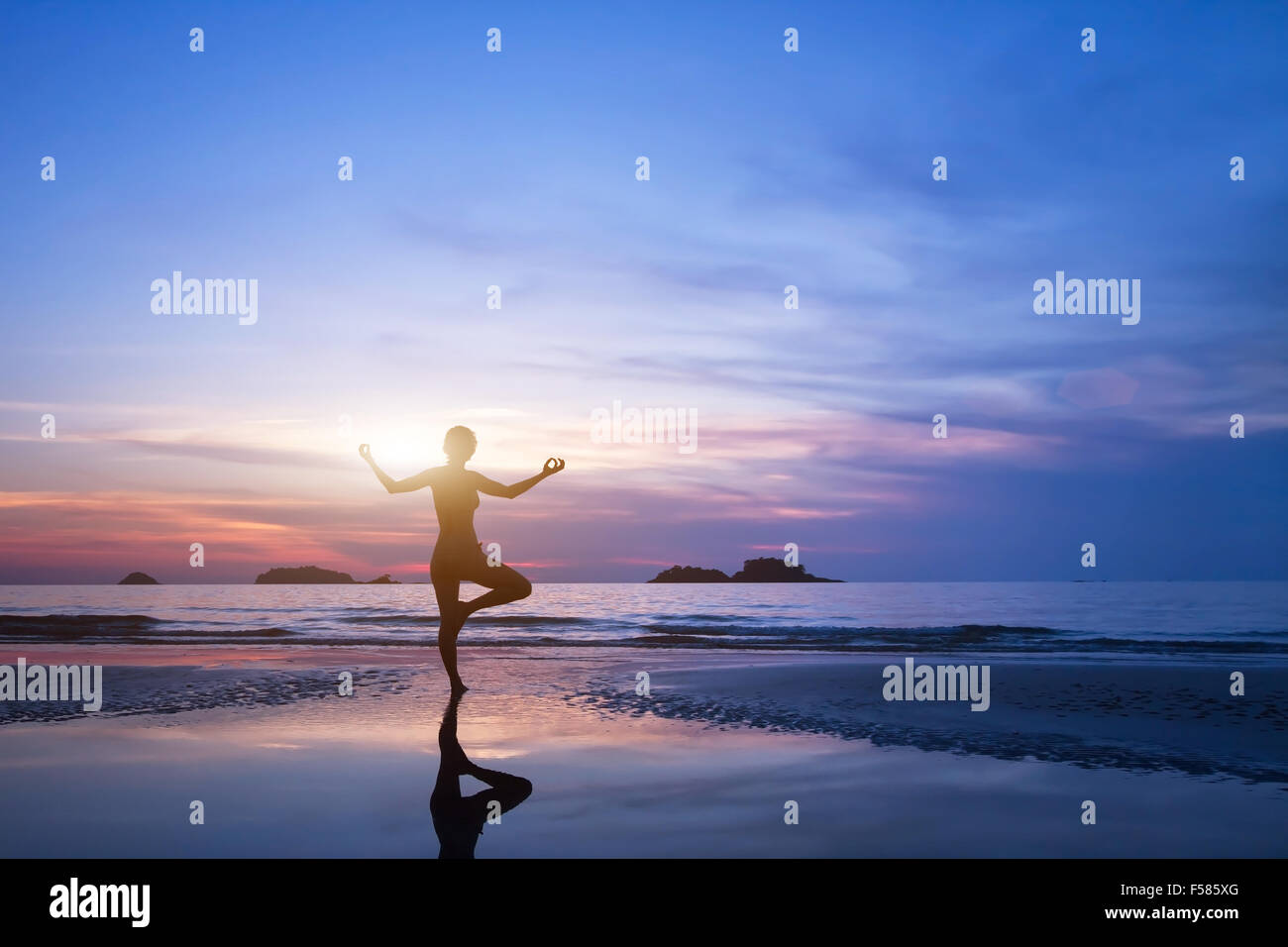 Yoga, Silhouette der Frau am Strand Stockfoto