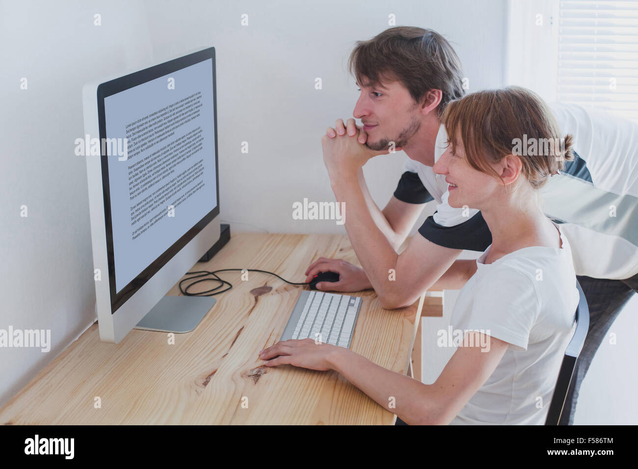 junges Paar sucht am Computer zu Hause Stockfoto