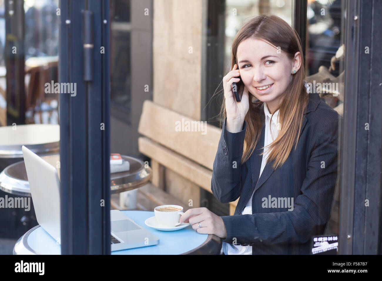 lächelnde Geschäftsfrau Gespräch telefonisch im café Stockfoto