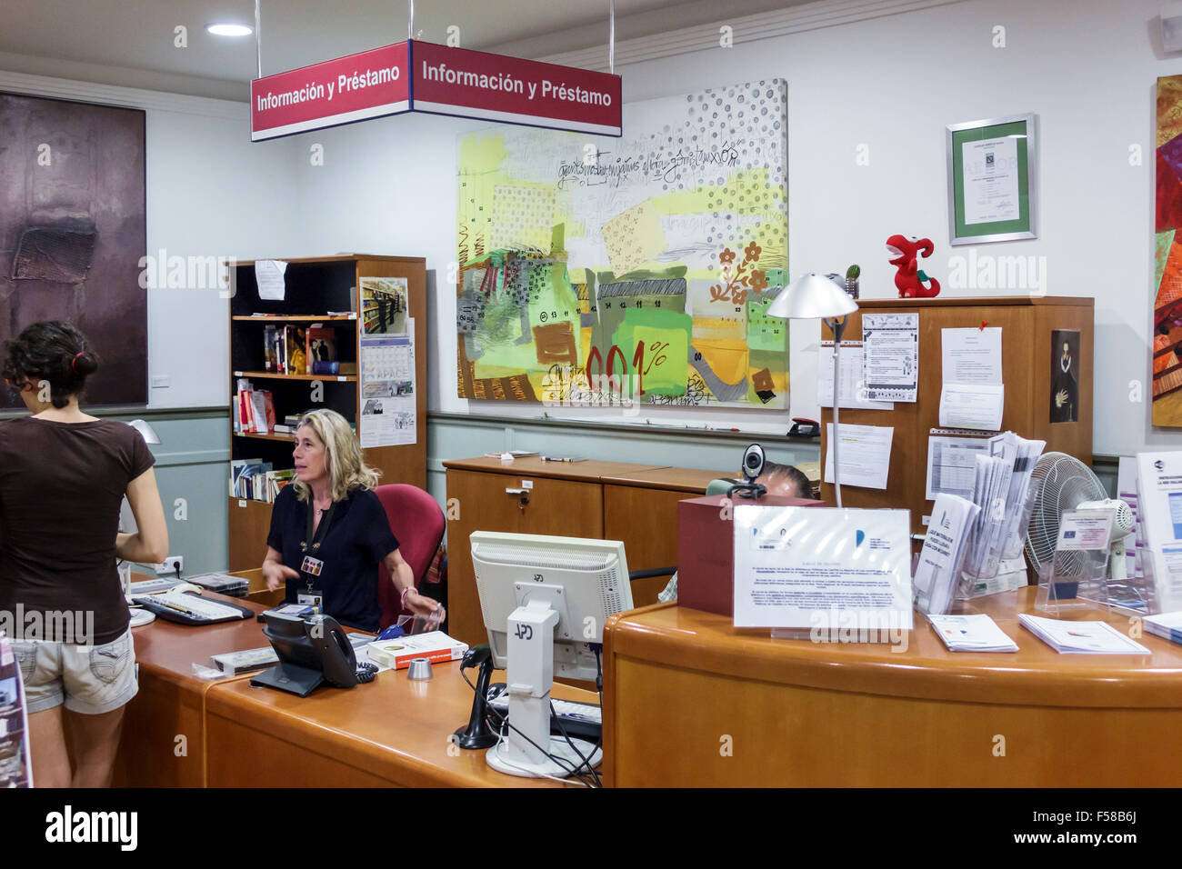 Toledo Spanien, Europa, Spanisch, Hispanic Biblioteca de Castilla-La Mancha, Bibliothek, Innenausstattung, Informationen, Checkout-Schalter, Bibliothekarin, Hispanic femal Stockfoto