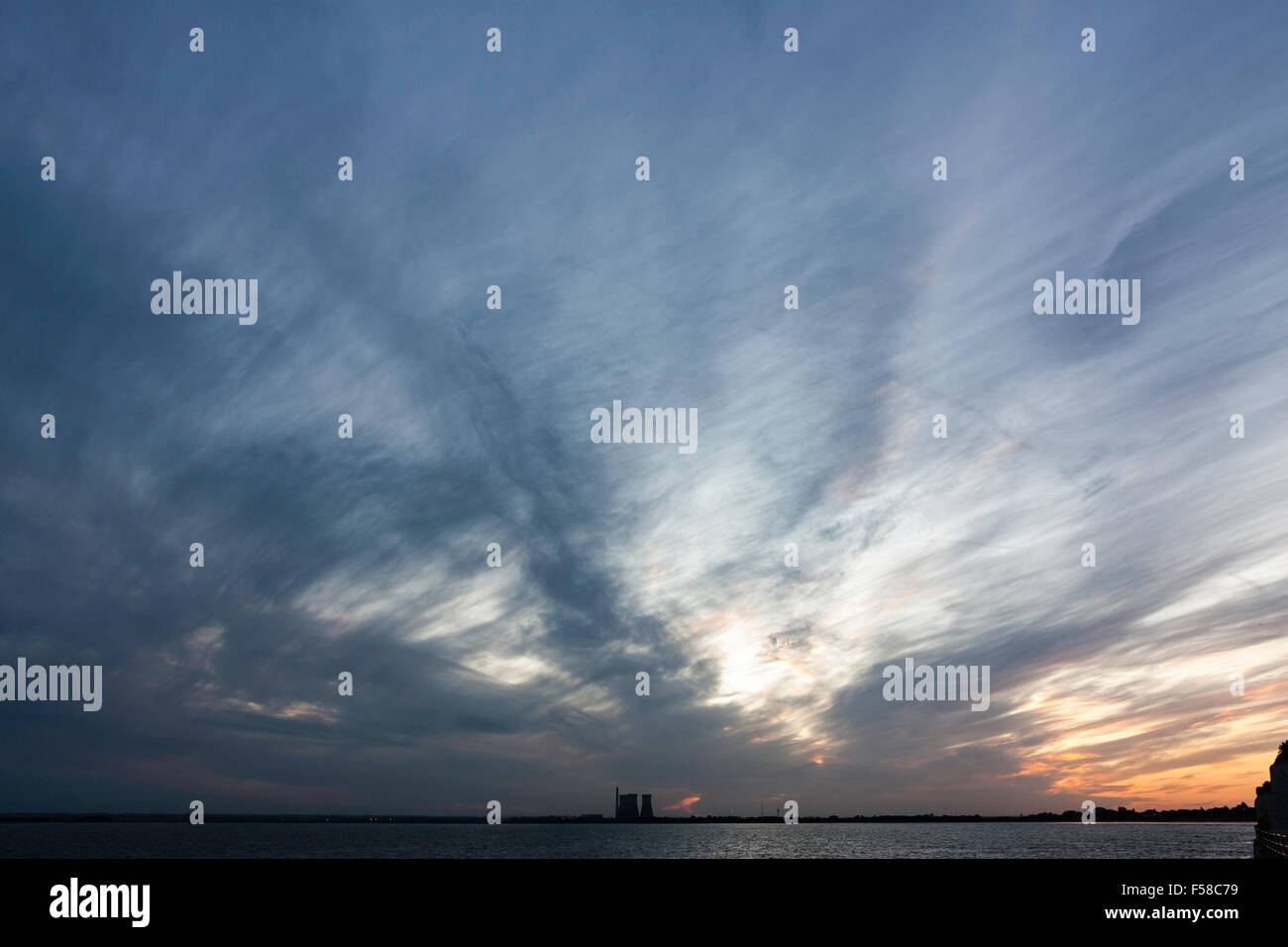 England, Ramsgate, Pegwell Bay. Abendhimmel während der Blauen Stunde mit Küste und Power Station an der Unterseite des Rahmens. Wispy Wolken vor blauem Himmel. Stockfoto