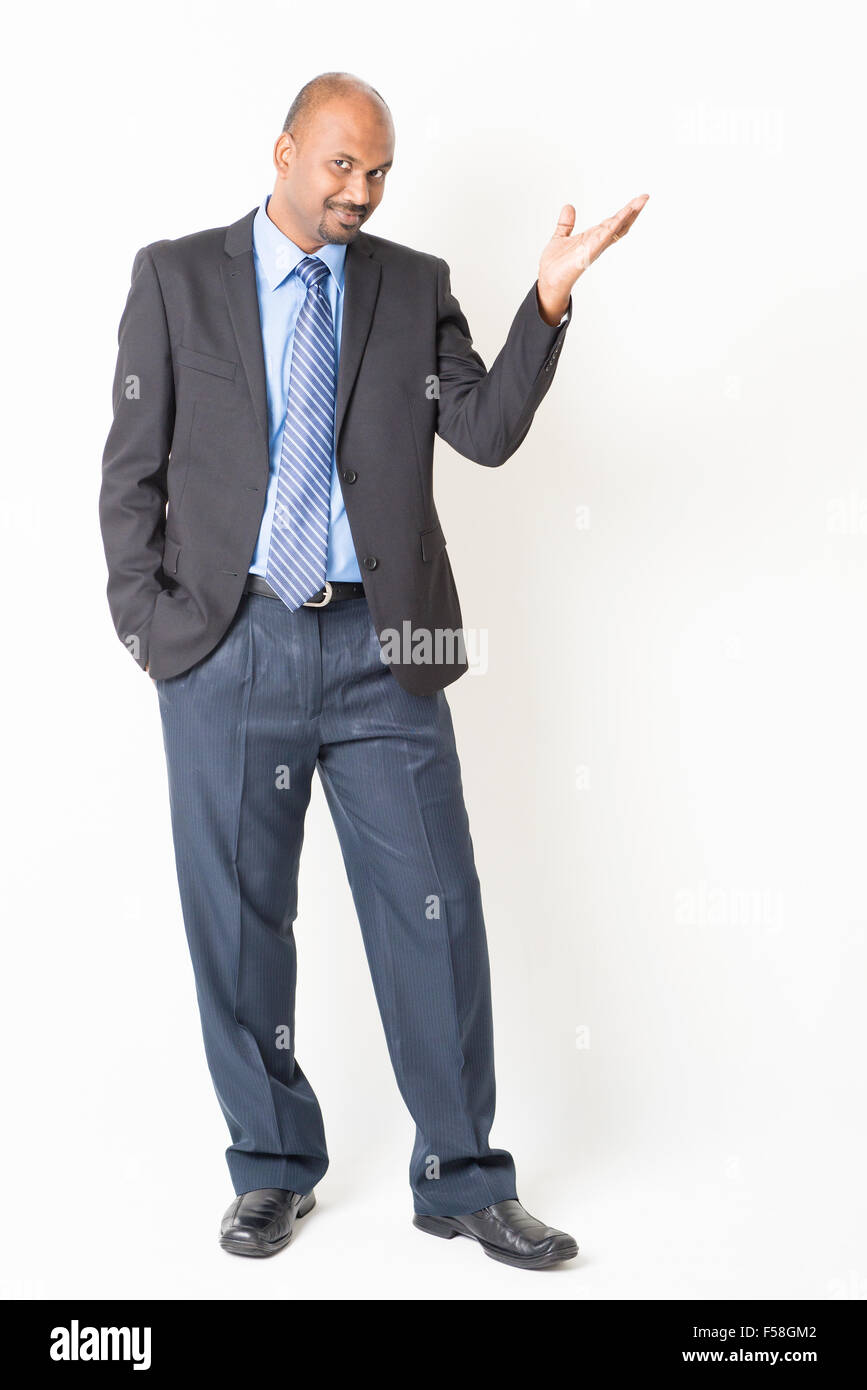 Porträt von Ganzkörper Reifen indischen Geschäft Mann Hand zeigen etwas auf einfarbigen Hintergrund stehend. Stockfoto