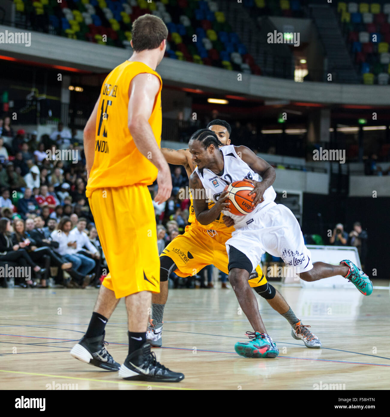 London, UK. 29. Oktober 2015. Manchester Giants Spieler und Head Coach Yorick Williams (12) treibt den Ball nach vorne, bei einem Angriff mit Londoner Brian Voelkel (15) und Nick Lewis (11) zu verteidigen, während das London Lions vs. Manchester Giants BBL-Spiel in der Kupfer-Box-Arena im Olympiapark. Manchester Giants gewinnen 90-82. Bildnachweis: Imageplotter/Alamy Live-Nachrichten Stockfoto