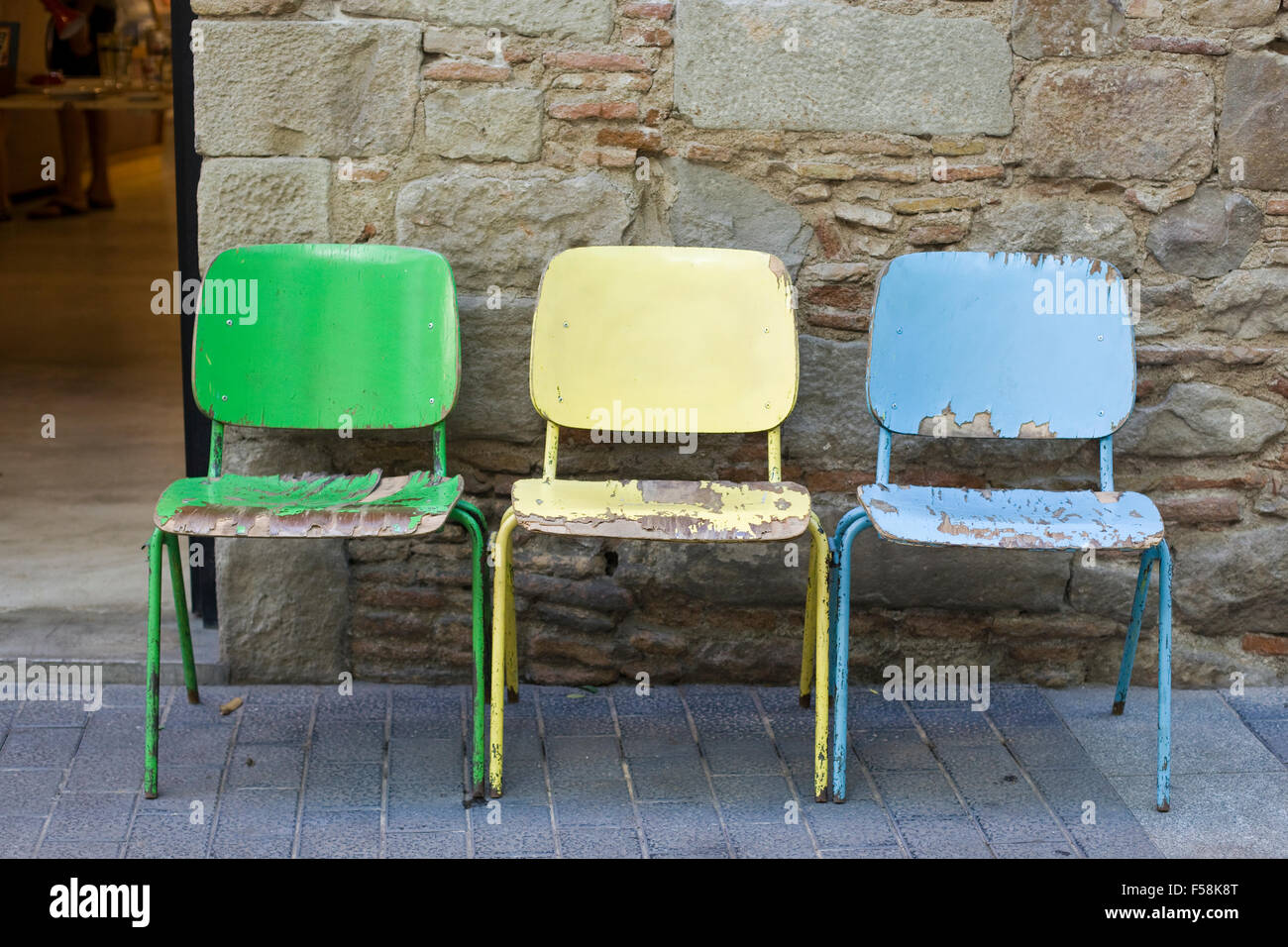 Abgeplatzte Farbe auf alte bunte Holzstühle auf der Straße Stockfoto