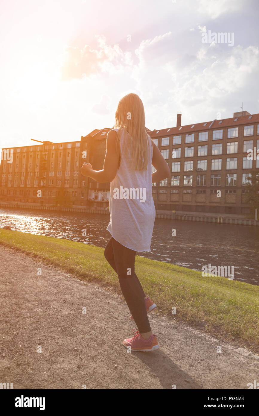 Junge Frau bei Gegenlicht Joggen Stockfoto