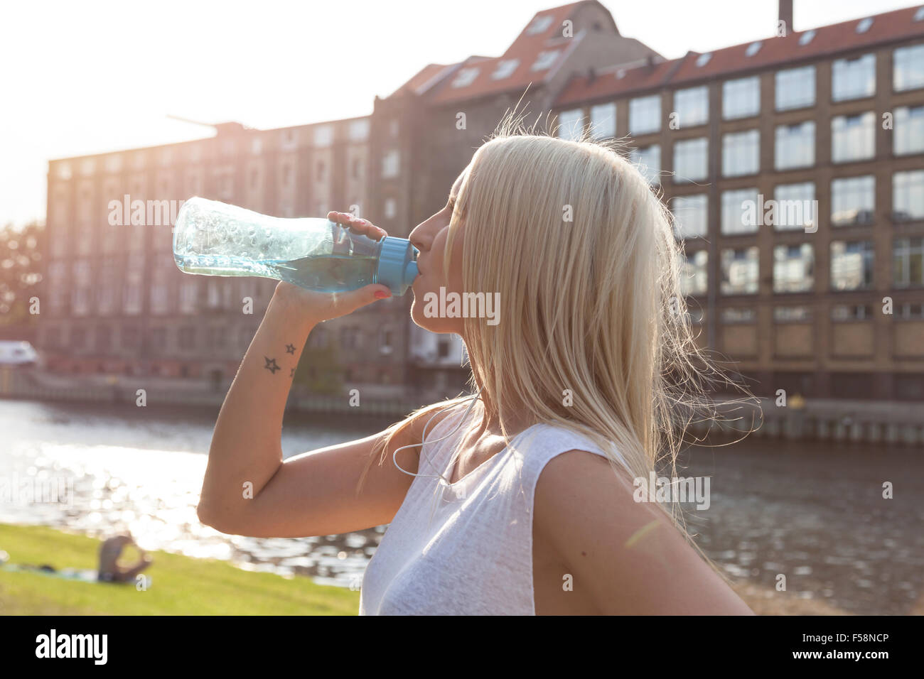 Frau trinkt aus einem Botte im Sommer in Berlin Stockfoto