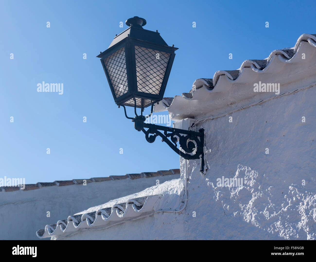 Reich verzierte Lampe in einem weiß getünchten Innenhof im Alcázar de San Juan in Kastilien-La Mancha, Spanien Stockfoto