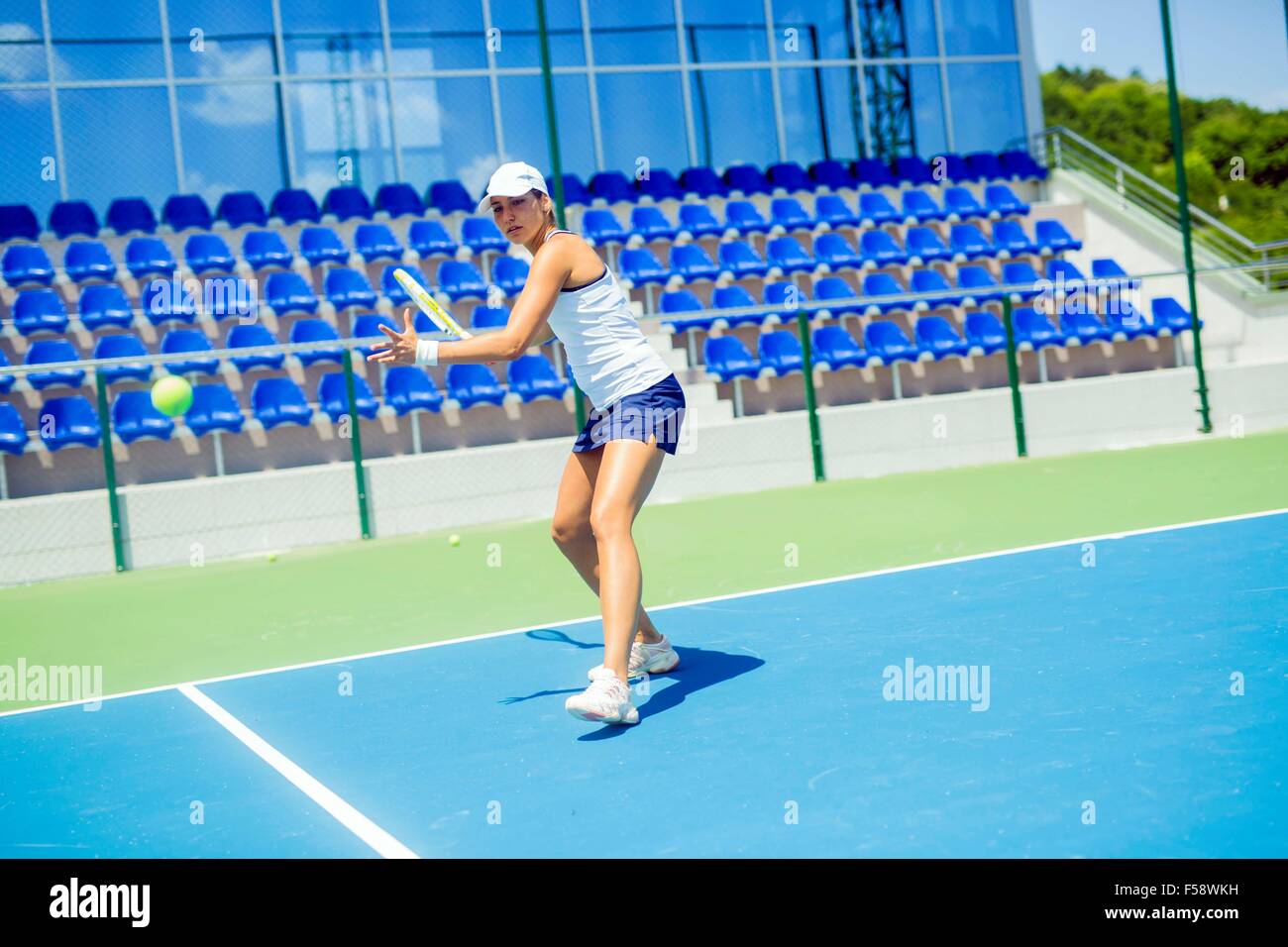 Schöne weibliche Tennisspieler in Aktion, schlagen eine Vorhand Stockfoto