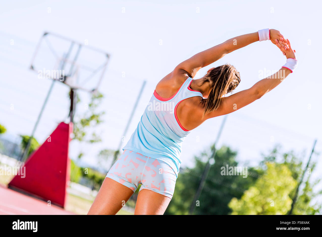 Schöne junge sportliche Frau erstreckt sich im Sommer vor der Ausführung Stockfoto
