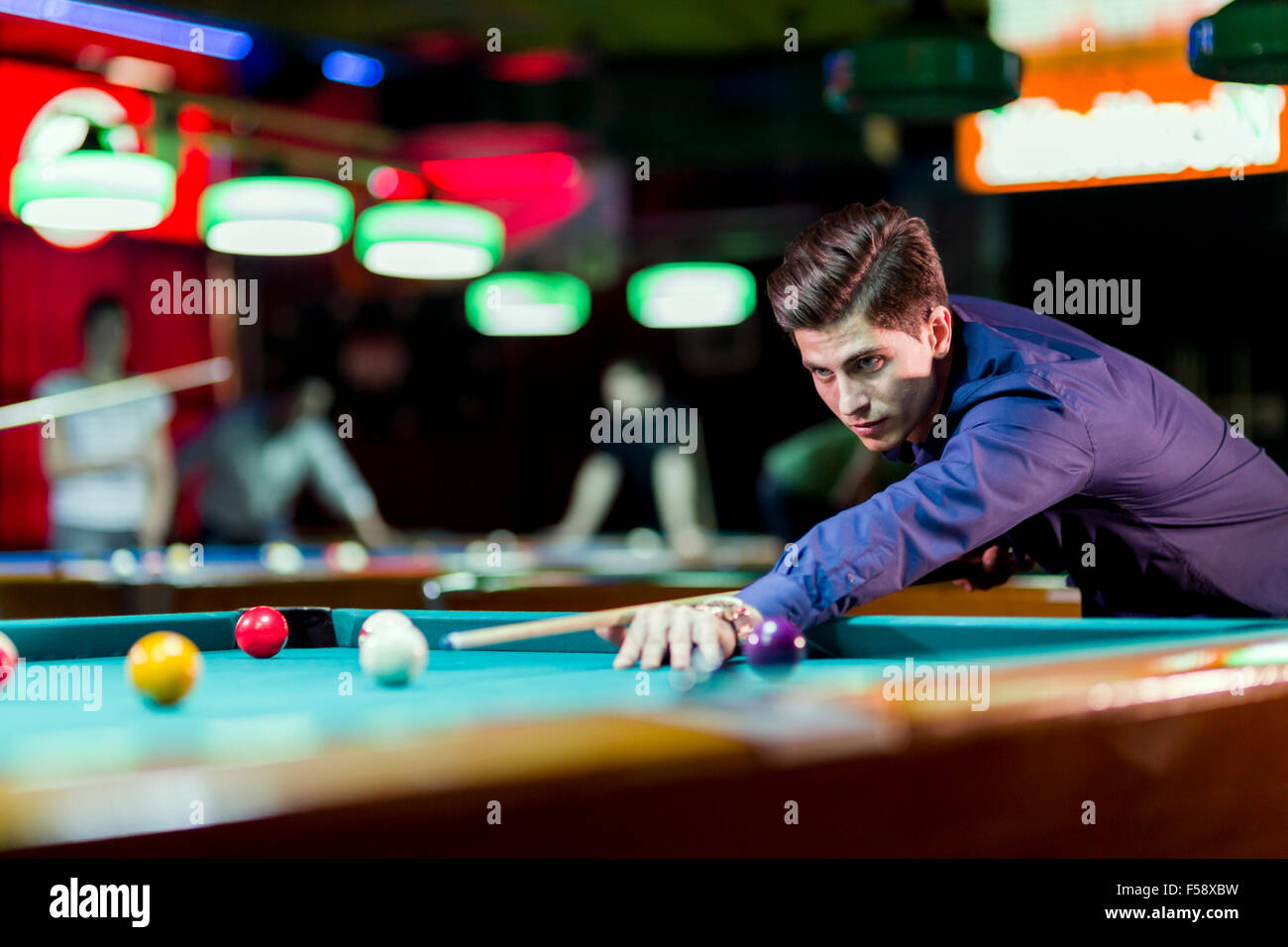 Schönen jungen Mann beugte sich über den Tisch beim Snooker spielen Stockfoto