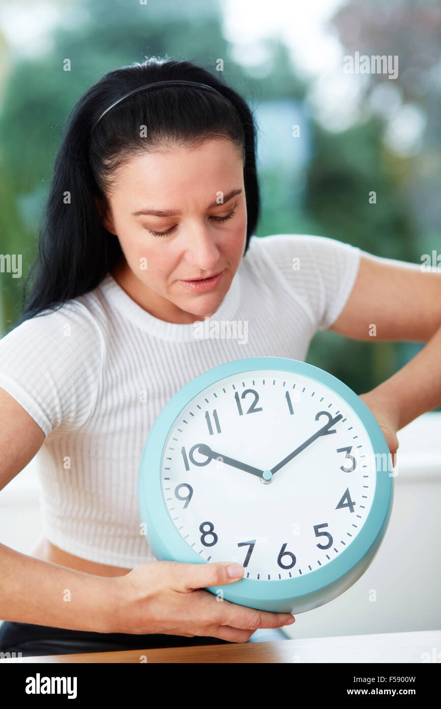 Einstellen der Uhrzeit auf einer Uhr Frau Stockfoto