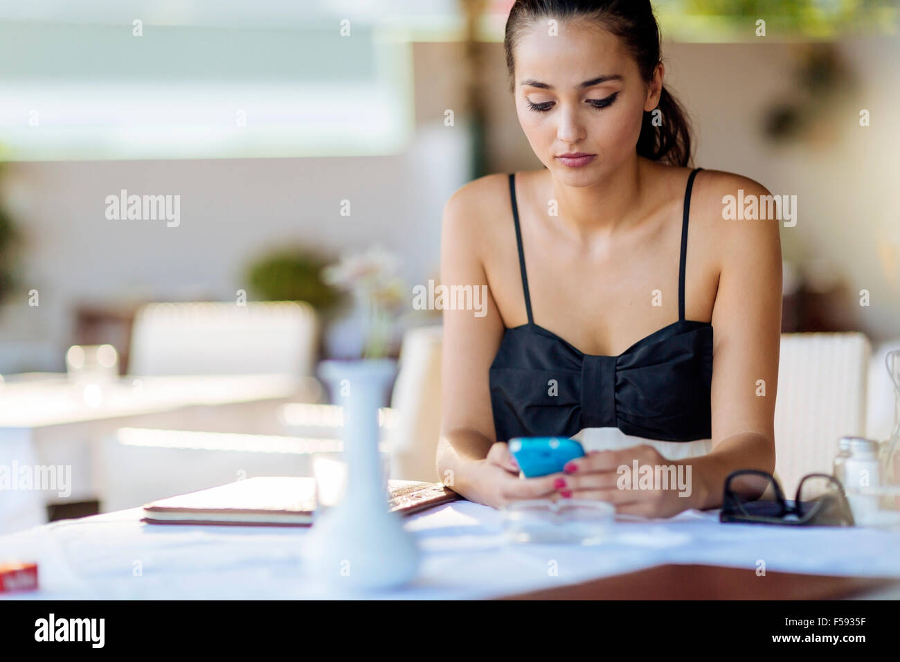 Schöne Frau mit Telefon im restaurant Stockfoto