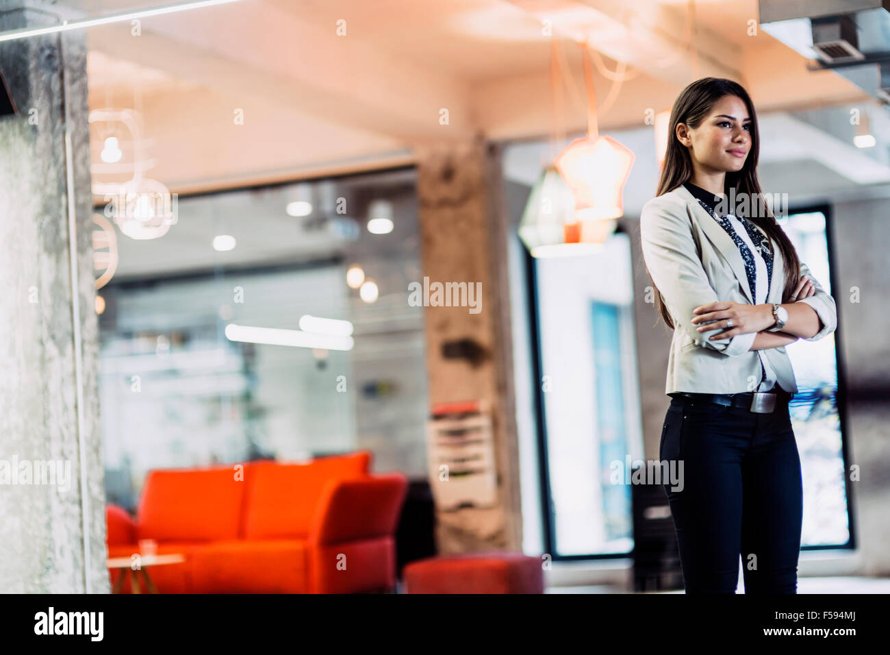 Zuversichtlich, Geschäftsfrau, stehend im Büro mit Hände gekreuzt Stockfoto