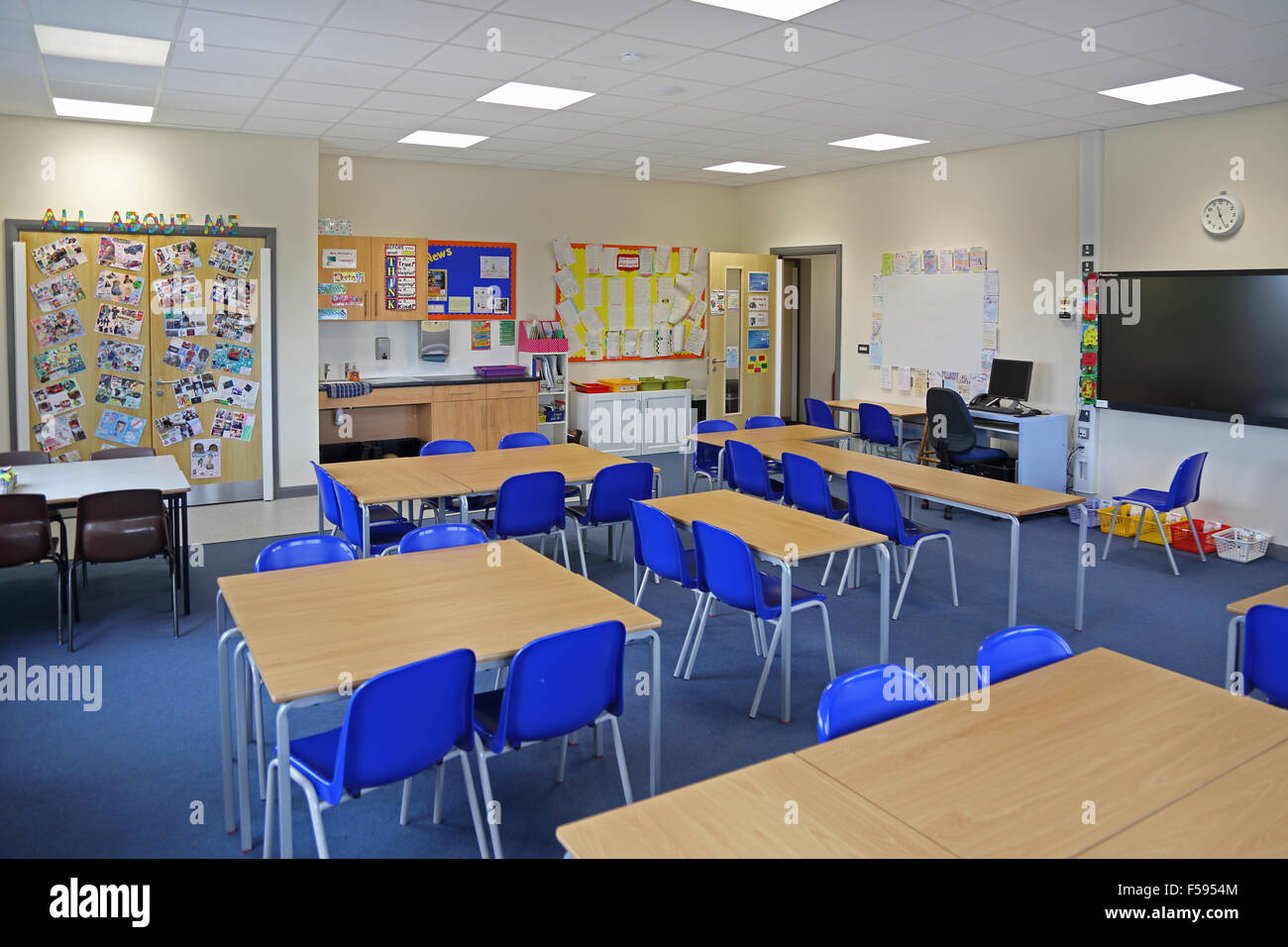 Ein Klassenzimmer in einem neu gebauten UK junior Schule. Zeigt, Schreibtische, Stühle, Lagerung und große Computer-Monitor-Bildschirm für den Unterricht Stockfoto