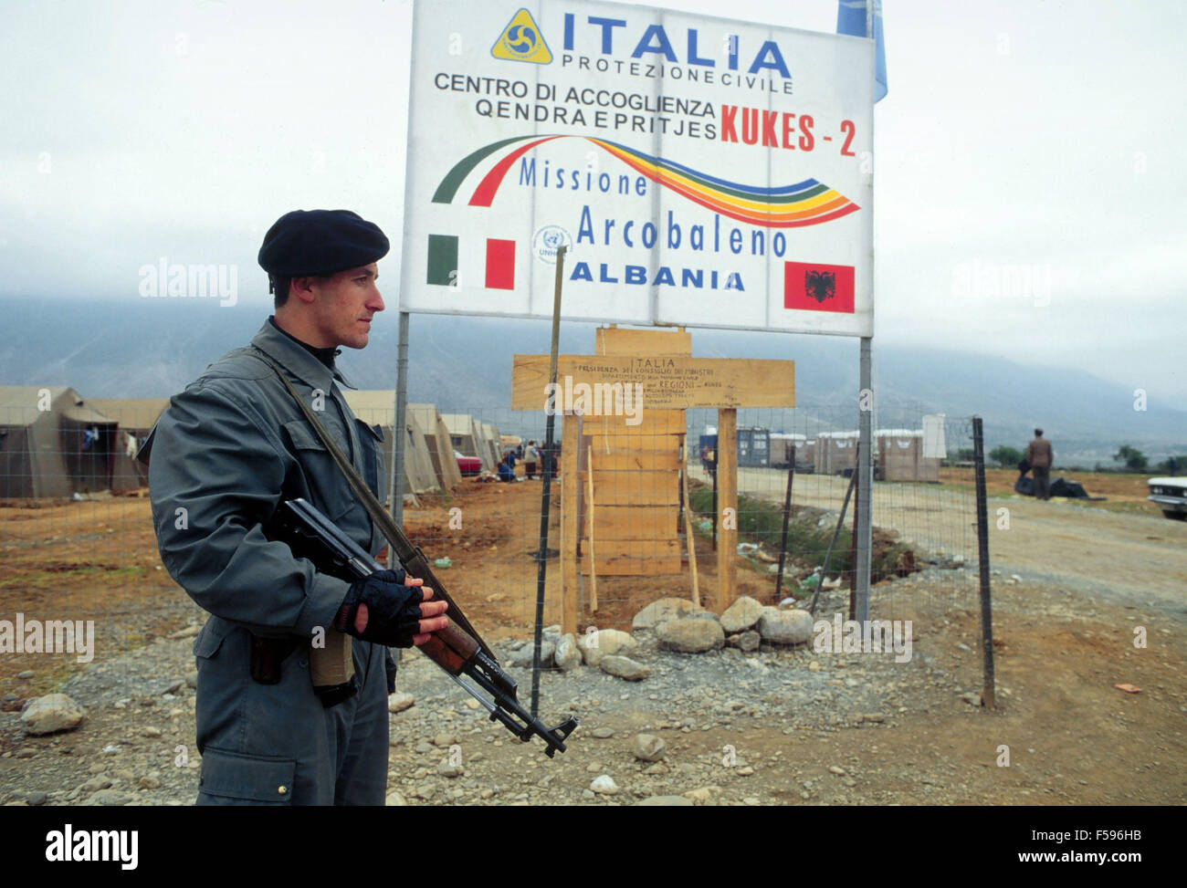 Krieg in ex-Jugoslawien, Kosovo-Krise, albanischer Polizist am Eingang des Lagers für Flüchtlinge organisiert von Italien in Kukes - Polizia Albanese all'ingresso del Campo pro ich Profughi dal heraus Organizzato dall'Italia ein Kukes Stockfoto