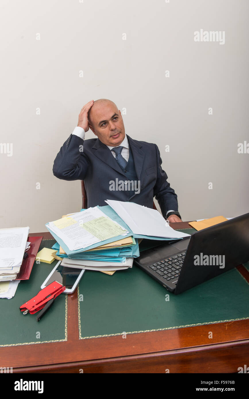 Ein quälender Geschäftsmann in der Krise, vor seinem pc. In seinem Arbeitszimmer, allein mit seiner Verzweiflung und seine Panik. Stockfoto