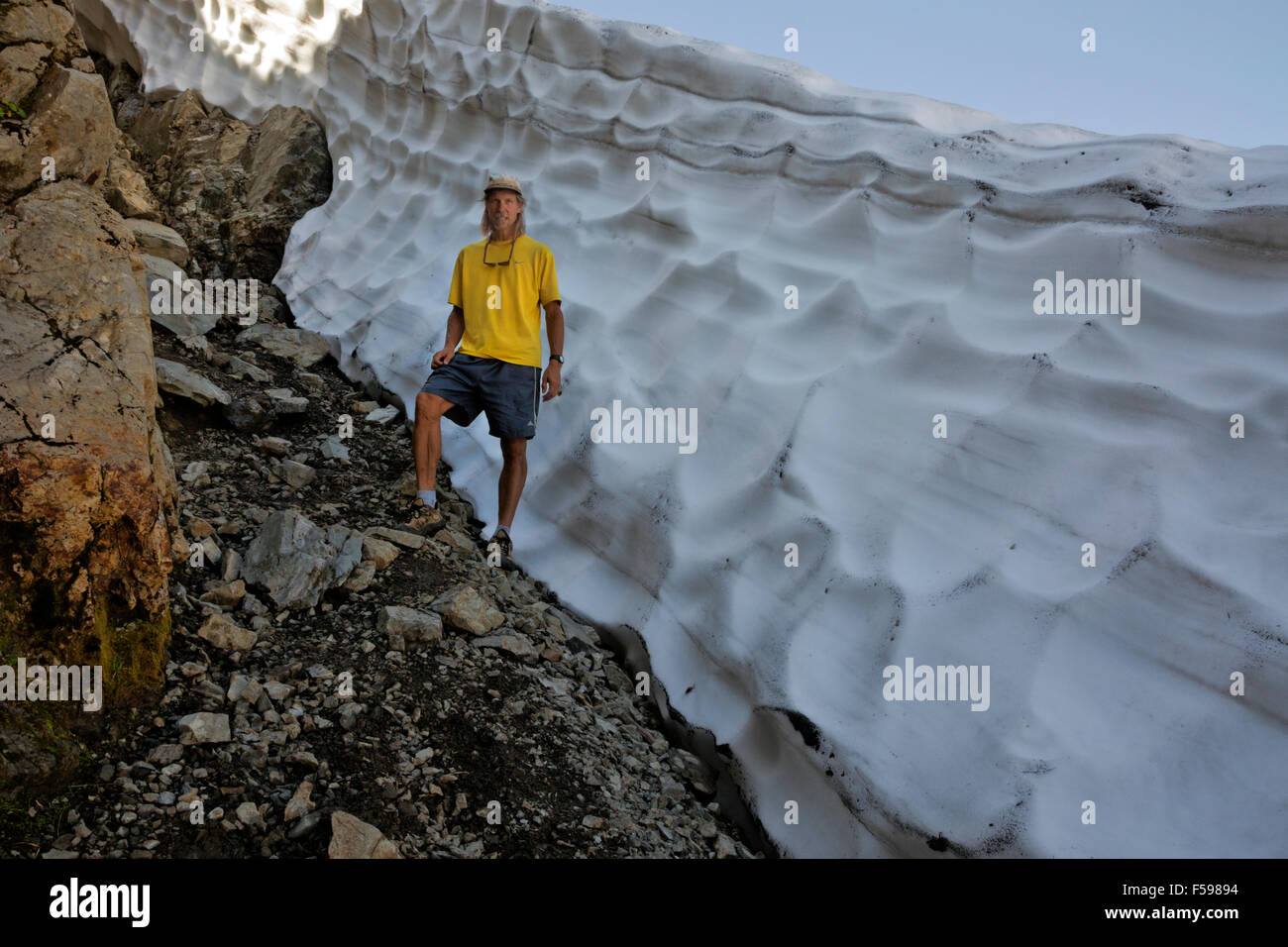 WASHINGTON - Wanderer Sockelleisten ein Snowbank unterwegs zwischen Tin-Pan-Lücke und drei Finger Lookout in Boulder River Wilderness Area. Stockfoto